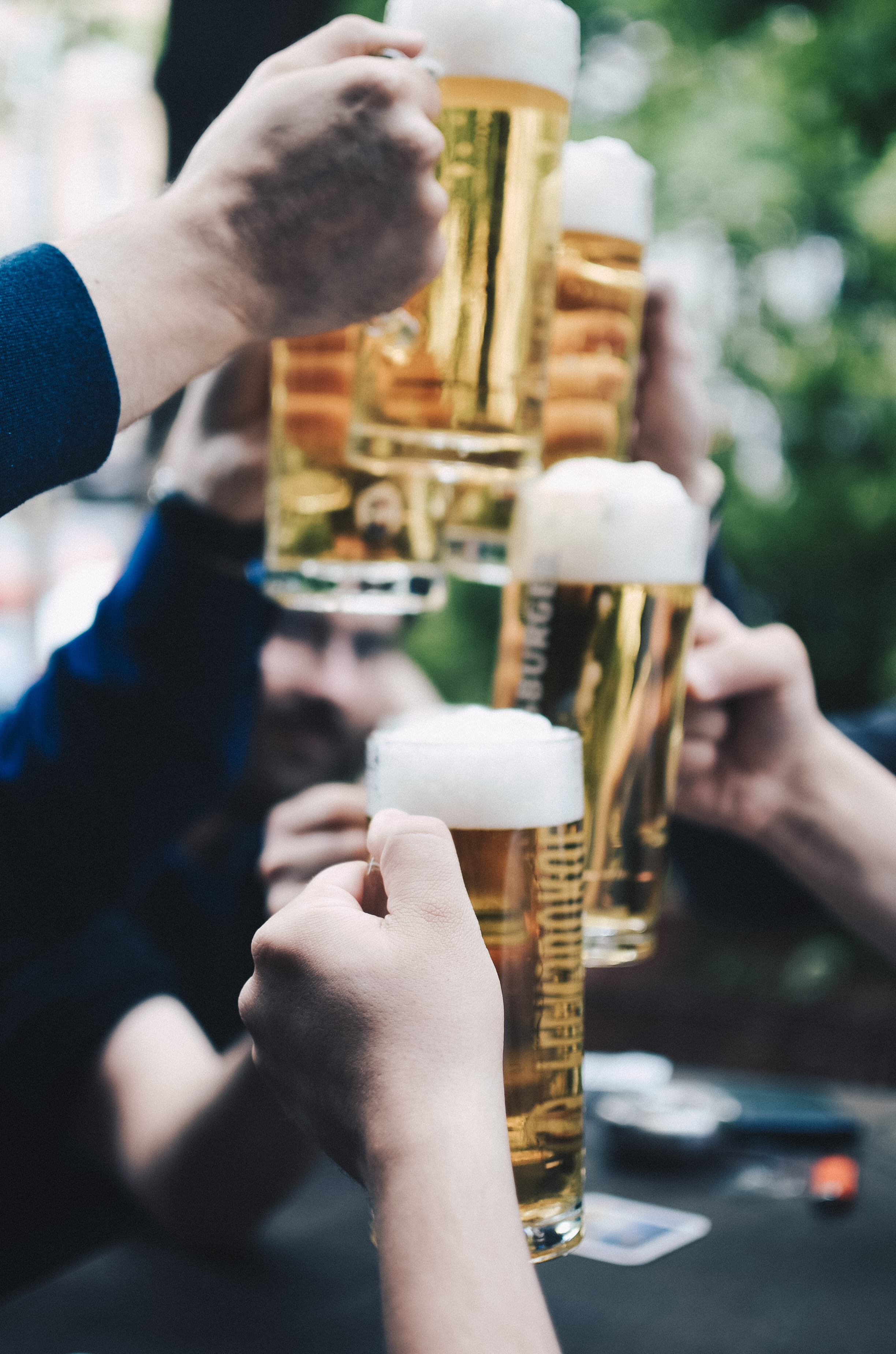 Several hands holding beer glasses